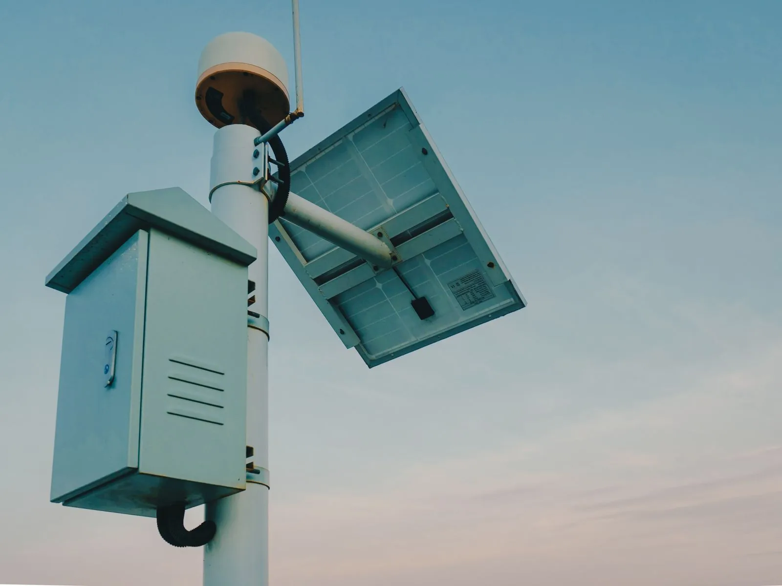 Solar-powered security camera and equipment enclosure on a pole